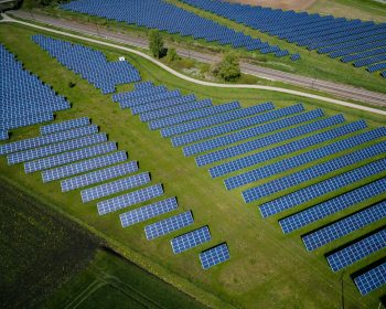 aerial photography of grass field with blue solar panels